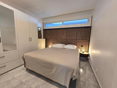 a bedroom with a large bed with a window at 2Cap d'Agde NATURISTE Grand T2 de standing avec GARAGE privé in Cap d'Agde
