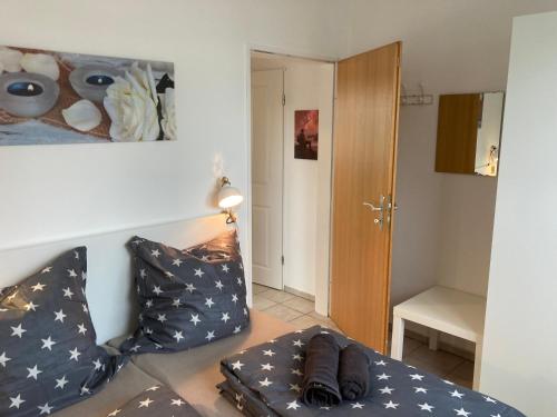 a room with a bed with an american flag pillows at CUXKieker - Moderne Ferienwohnung mit Pep in Cuxhaven-Sahlenburg, WLAN, Parkplatz und Gartenblick, nah am Nordseestrand und Wernerwald in Cuxhaven