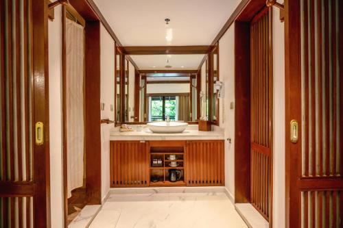 a bathroom with a sink and a mirror at Novotel Bogor Golf Resort in Bogor