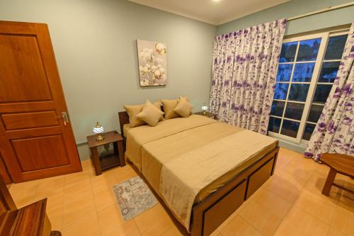 a bedroom with a bed and a window at Villa 53 in Battaramulla