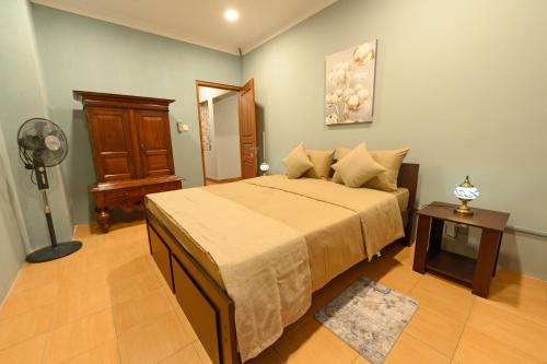 a bedroom with a large bed and a fan at Villa 53 in Battaramulla