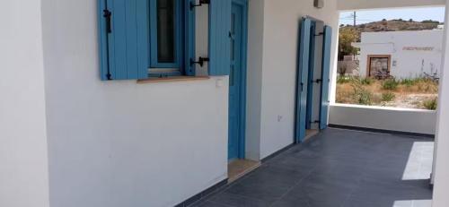 a hallway with blue doors on a white building at #7 Lipsi Port Apartment Sea Views-Ground floor-No#7 in Lipsoi
