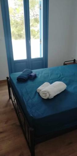 a blue bed with two pillows on top of it at #7 Lipsi Port Apartment Sea Views-Ground floor-No#7 in Lipsoi