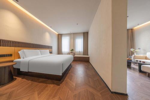 a bedroom with a large white bed and a bathroom at Yi Nian · Fangcun Hotel in Nanchang