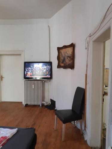 a living room with a television and a chair at Villa de Weser Hameln in Hameln
