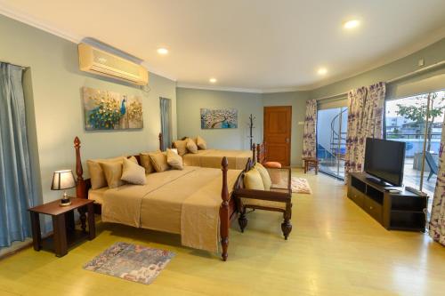 a bedroom with two beds and a flat screen tv at Villa 53 in Battaramulla
