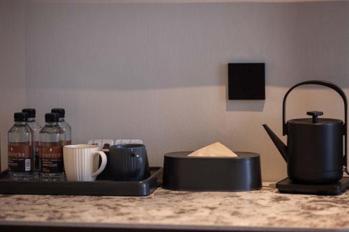 a counter top with cups and a coffee maker on it at Yi Nian · Fangcun Hotel in Nanchang