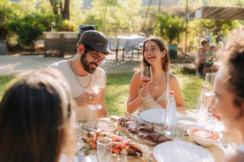 a group of people sitting around a table with wine glasses at Vitrage Holiday Village and Spa in Bet Hillel