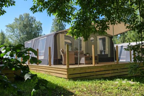 a house with a deck with chairs on it at Topcamp Bogstad - Oslo in Oslo