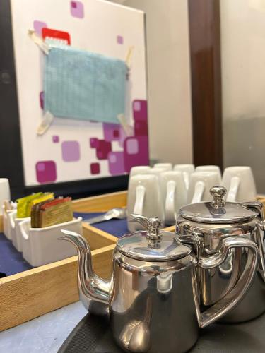 a silver tea pot sitting on a table with chairs at Vaydantaa - Luxury Boutique Resort Mussoorie in Mussoorie