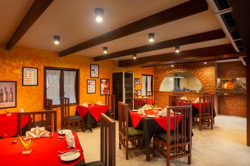 a restaurant with tables and chairs with red table cloth at Novotel Bogor Golf Resort in Bogor