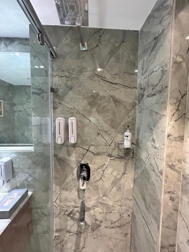 a bathroom with a shower with a stone wall at Vaydantaa - Luxury Boutique Resort Mussoorie in Mussoorie