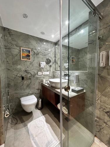a bathroom with a toilet and a sink and a shower at Vaydantaa - Luxury Boutique Resort Mussoorie in Mussoorie