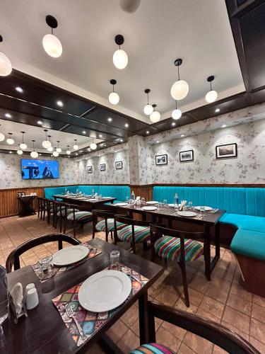a restaurant with tables and chairs and a blue couch at Vaydantaa - Luxury Boutique Resort Mussoorie in Mussoorie