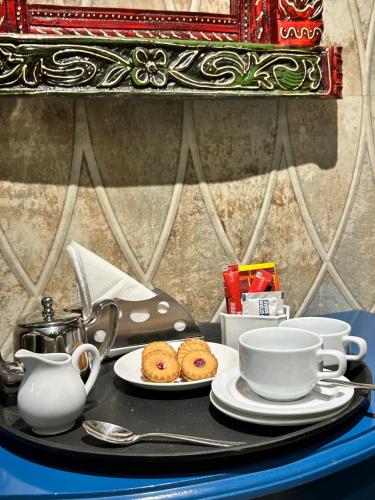 a tray with tea cups and muffins on a table at Vaydantaa - Luxury Boutique Resort Mussoorie in Mussoorie