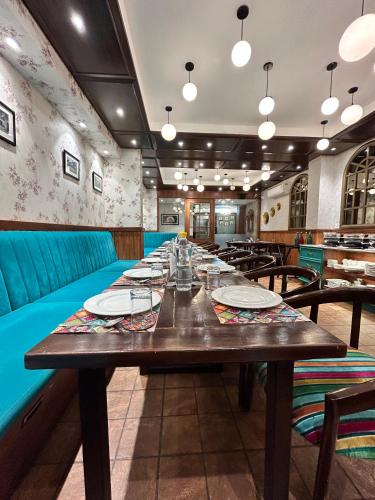 a long dining room with a long wooden table at Vaydantaa - Luxury Boutique Resort Mussoorie in Mussoorie