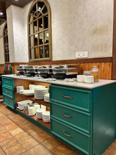 a kitchen with green cabinets and white plates on display at Vaydantaa - Luxury Boutique Resort Mussoorie in Mussoorie