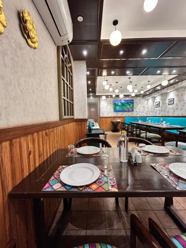 a dining room with a table with plates on it at Vaydantaa - Luxury Boutique Resort Mussoorie in Mussoorie