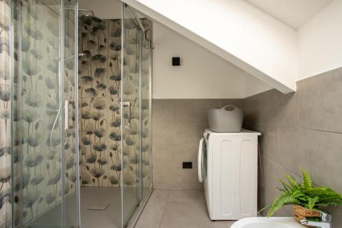 a bathroom with a toilet and a glass shower at Villa Tivano, vista mozzafiato in Colico