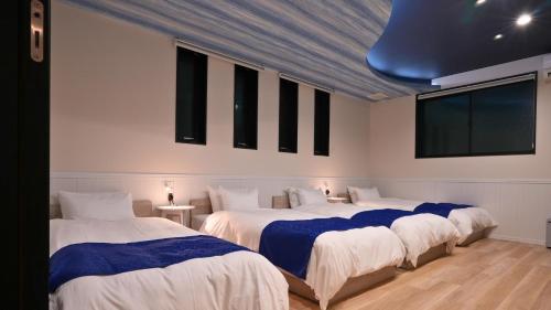 three beds in a room with white walls at LAKE villa CHITOSE in Hikone