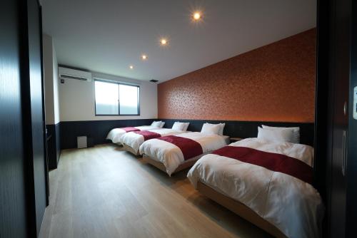 a room with four beds in a room with a window at LAKE villa CHITOSE in Hikone