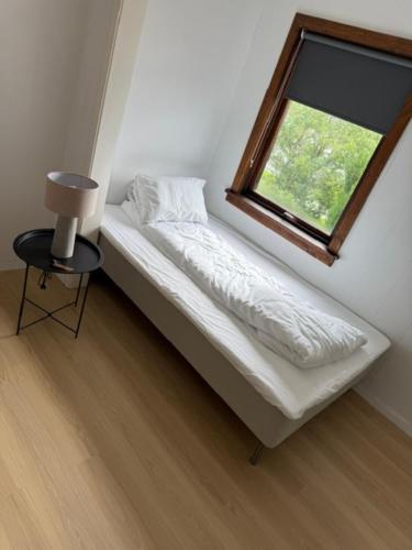 a small bed in a room with a window at Sunde Fjord view, easy and cheap! in Sula