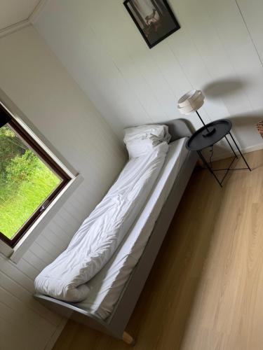 a bed in a room with a window at Sunde Fjord view, easy and cheap! in Sula