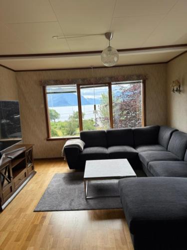 a living room with a couch and a table at Sunde Fjord view, easy and cheap! in Sula