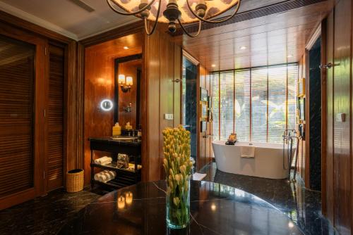 a bathroom with a tub and a vase of flowers on a table at Hotel Indigo Bali Seminyak Beach by IHG in Seminyak