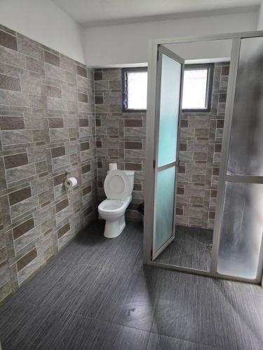 a bathroom with a toilet and a glass shower at Island Accommodation Suva Premier Hospitality in Suva
