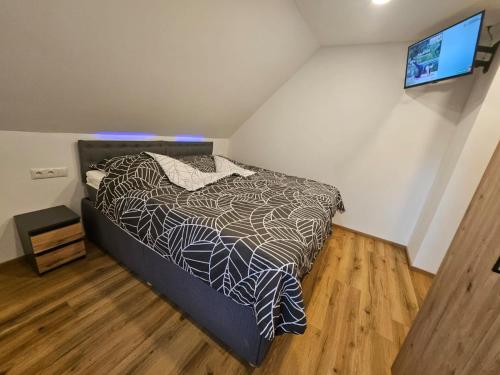 Un dormitorio con una cama y un televisor en una pared. en Gasthaus Eichholzer, en Murau