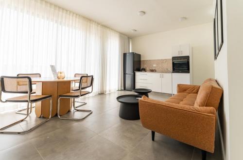 a living room with a couch and a table with chairs at UG Boutique - סוויטות מדהימות ומעוצבות מול הכנרת in Tiberias