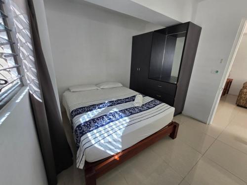 a small bedroom with a bed and a black cabinet at Island Accommodation Suva Premier Hospitality in Suva