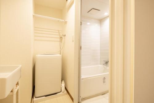 a bathroom with a toilet and a sink and a tub at 難波民泊301 in Osaka