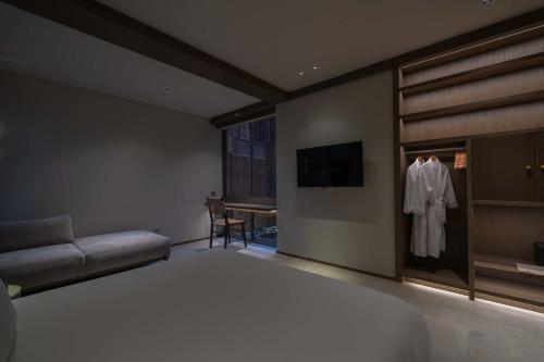 a bedroom with a bed and a couch and a table at Harvest Day Hoi An in Hoi An