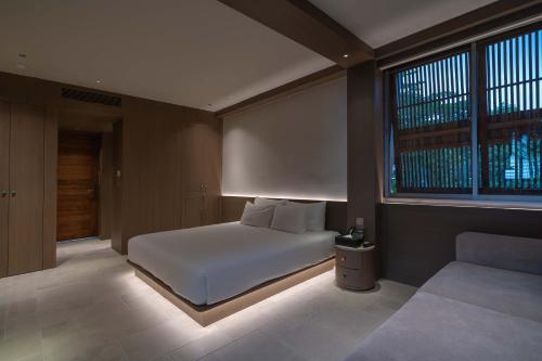 a bedroom with a white bed and a window at Harvest Day Hoi An in Hoi An