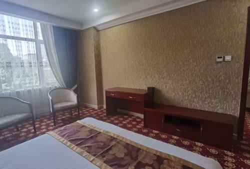 a room with a bed and a desk and a window at Kohi Afsaron in Dushanbe