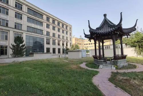 a gazebo in a yard next to a building at Kohi Afsaron in Dushanbe
