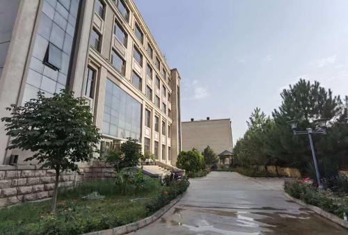 an empty street in front of a large building at Kohi Afsaron in Dushanbe