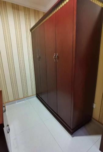 a large wooden cabinet in a room with white tile at Kohi Afsaron in Dushanbe