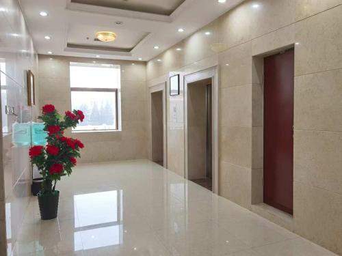a lobby with a plant with red flowers in a pot at Kohi Afsaron in Dushanbe