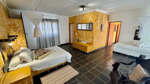 a hotel room with two beds and a chair at Roy's Rest Camp in Groutfontein