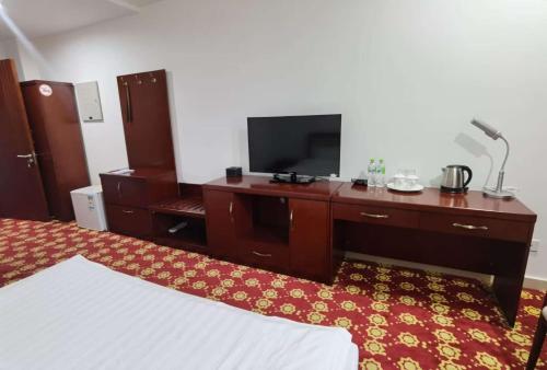 a hotel room with a bed and a tv on a desk at Kohi Afsaron in Dushanbe