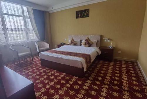 a hotel room with a bed and a red carpet at Kohi Afsaron in Dushanbe