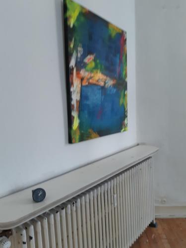 a painting on a wall above a radiator at Villa de Weser Hameln in Hameln