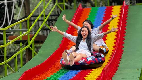 two girls are riding on a roller coaster at Novotel Bogor Golf Resort in Bogor