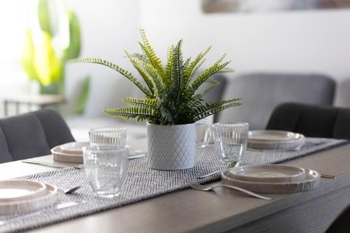a table with plates and a potted plant on it at Spazioso appartamento con terrazzo Navigli, Bocconi in Milan
