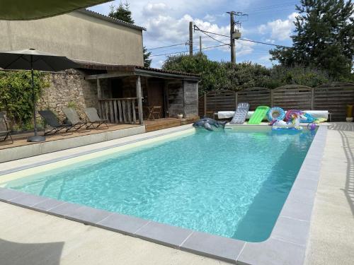 une piscine dans une cour avec un parasol dans l'établissement La murette, à Solignac