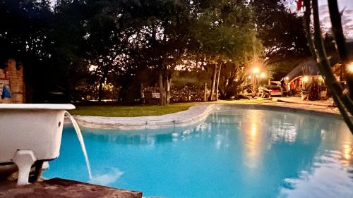 a swimming pool with a hose in a yard at Roy's Rest Camp in Groutfontein