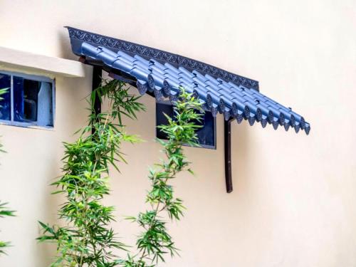 awning on the side of a building with plants at Tràng An Sunny River Homestay in Ninh Binh